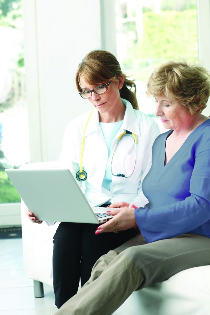 Image of doctor and patient looking at a laptop